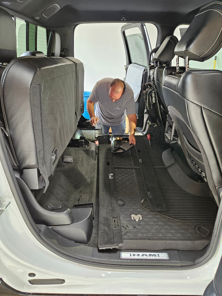 A 2019-2024 RAM 1500 TRX showing back seats up and floor preparing to be cut for storage install